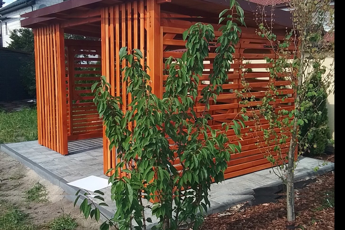 Pergola z ażurowych listew przy domu